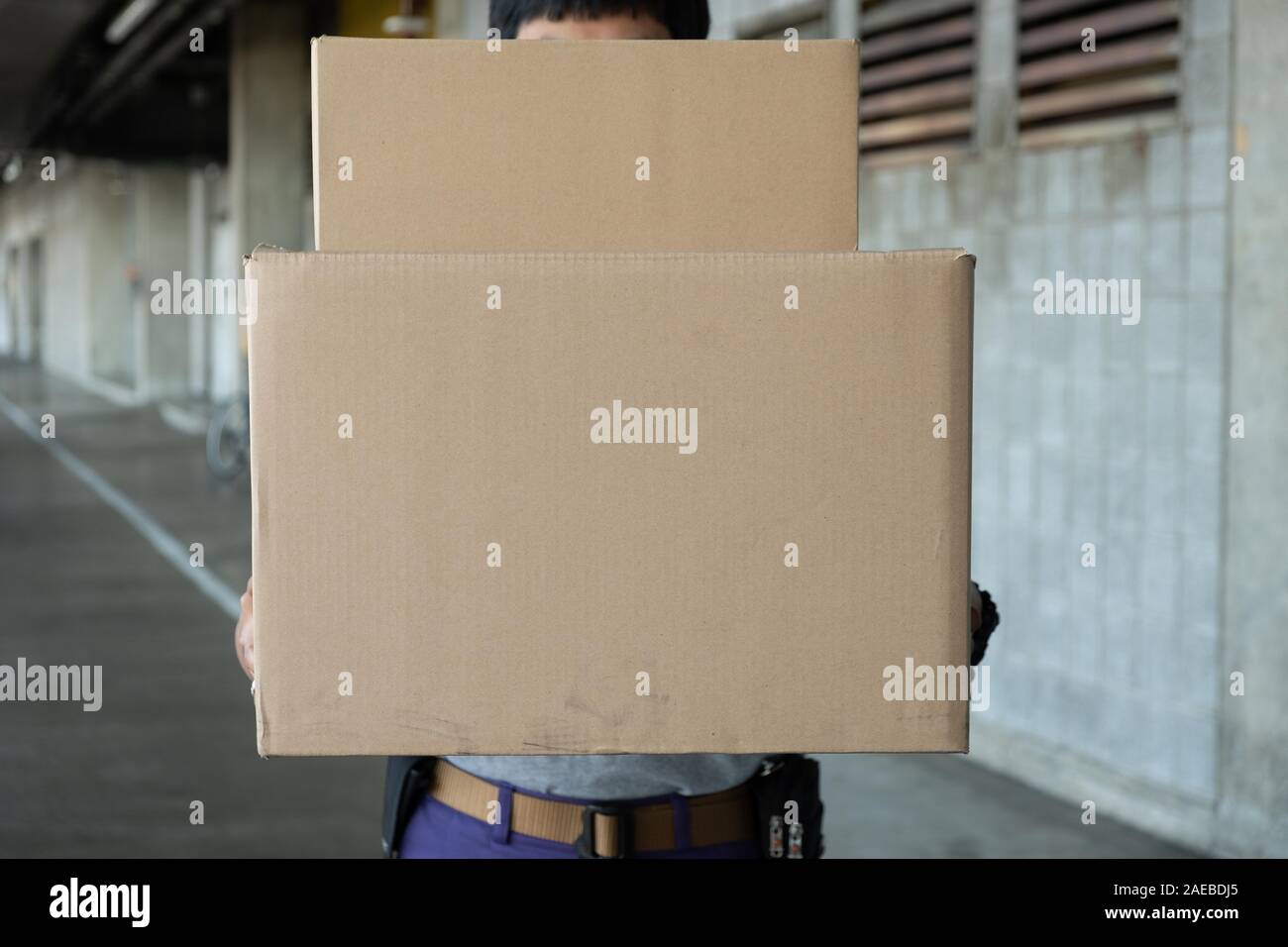 Junge delivery man Handhabung Pakete bestellen. Versand und Logistik im e-commerce Industrie liefern durch Postboten. Stockfoto