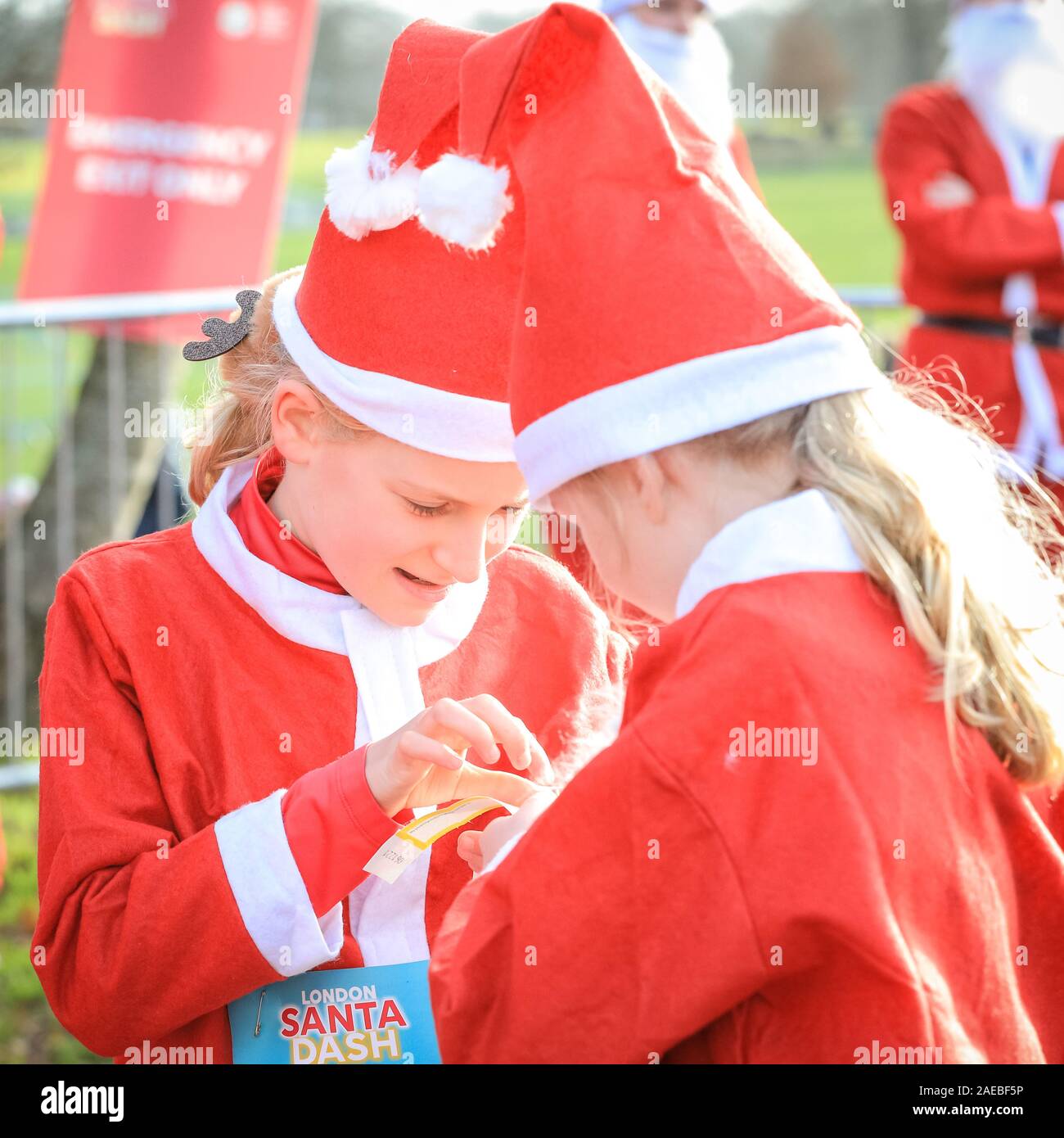 Brockwell Park, London, UK, 08. Dez 2019. Zwei kleine Weihnachtsmänner für den Lauf vorzubereiten. Um 3000 Santa Läufer verkleidet als Weihnachtsmann melden Sie in der jährlichen London Santa Dash 2019. In diesem Jahr 5k und 10k Strecken für Läufer aller Altersgruppen führt durch Brockwell Park, South London. Die Santa Dash hebt Geld schwerkranker Kinder in der Great Ormond Street Hospital (GOSH) die Chance auf eine bessere Zukunft zu geben. Stockfoto