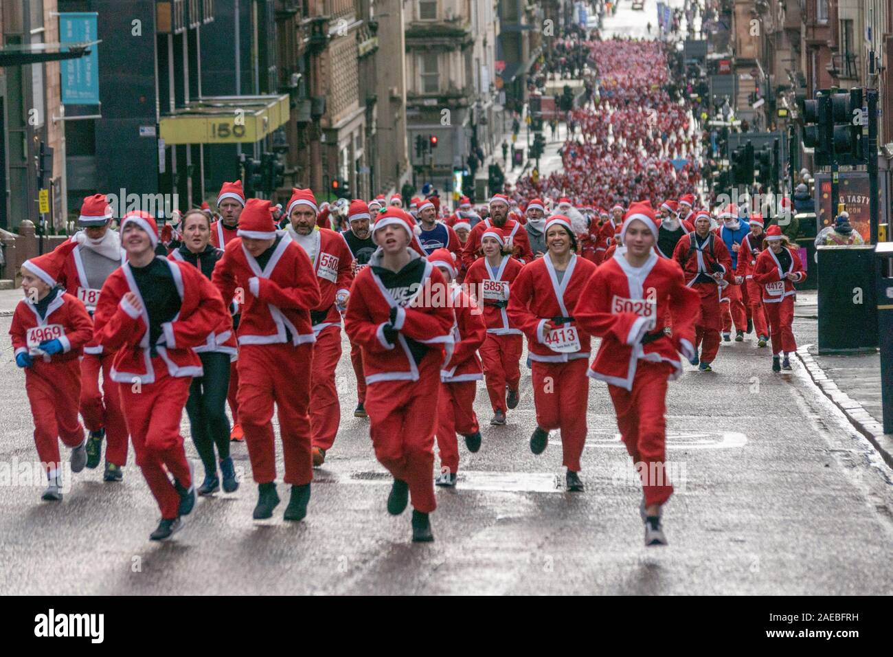 Glasgow, UK. 8. Dezember 2019. Die jährlichen 5K Santa Dash von George Square mit ca. 8000 Menschen gekleidet wie Santa im Regen laufen und Geld für wohltätige Zwecke. Credit: Richard Gass/Alamy leben Nachrichten Stockfoto