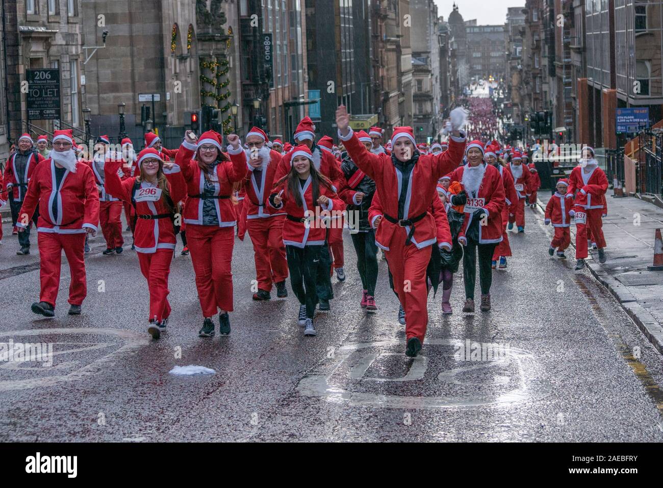 Glasgow, UK. 8. Dezember 2019. Die jährlichen 5K Santa Dash von George Square mit ca. 8000 Menschen gekleidet wie Santa im Regen laufen und Geld für wohltätige Zwecke. Credit: Richard Gass/Alamy leben Nachrichten Stockfoto