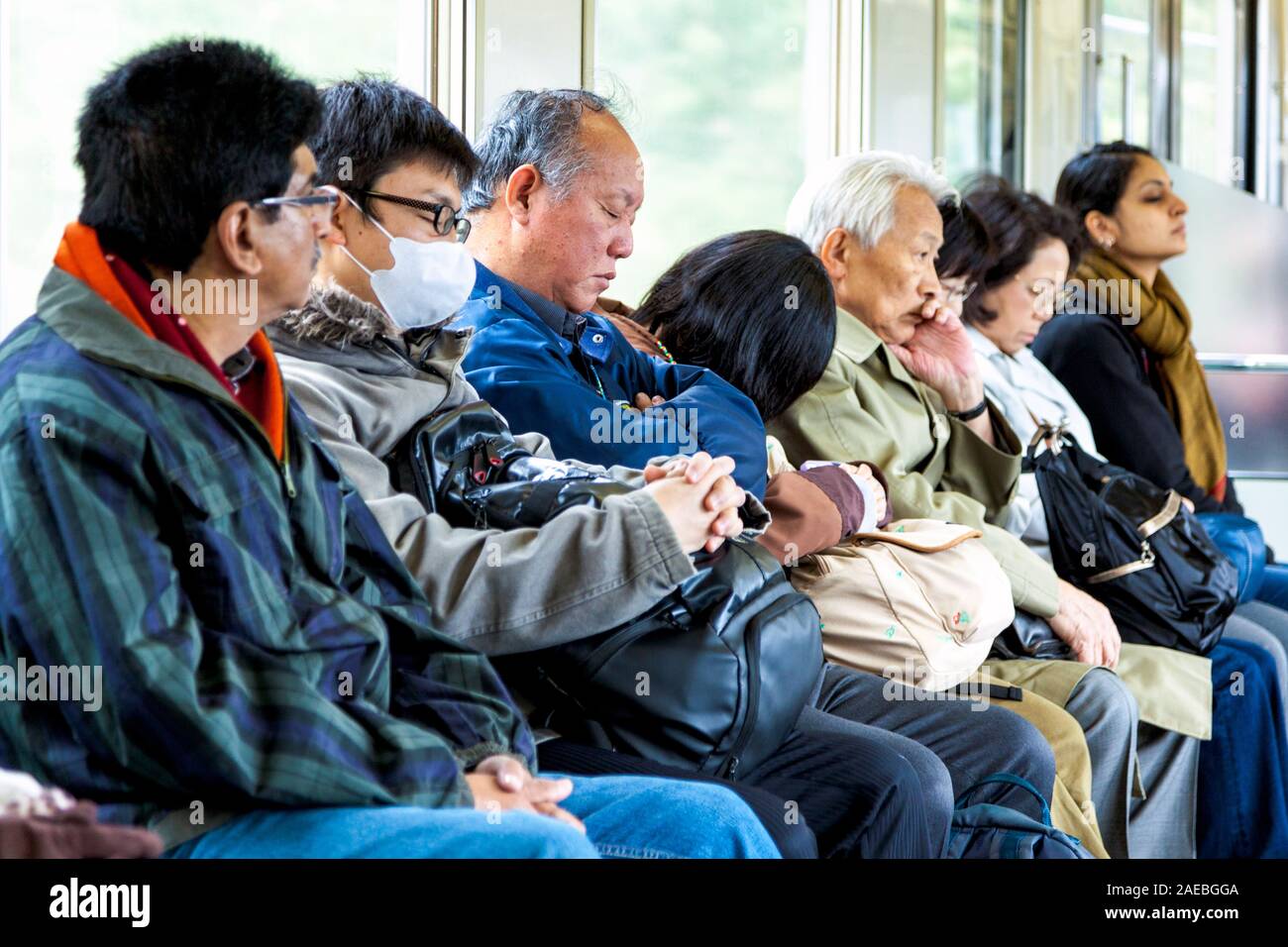 Müde Leute schlafen auf einem Zug in Tokio, Japan. Stockfoto