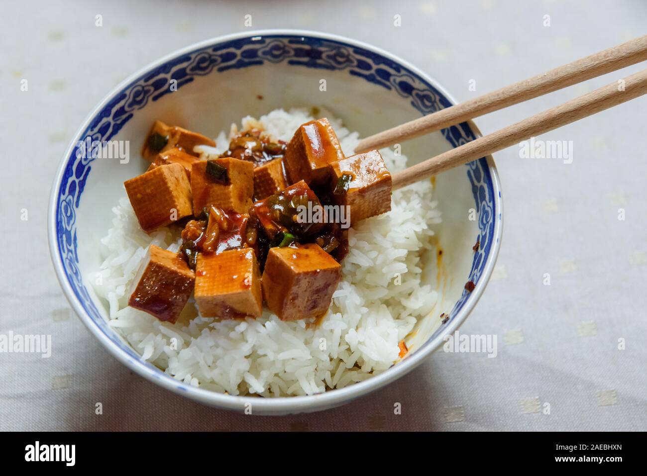 Schüssel mit Tofu, Reis und Soja Sauce. Mit hölzernen Eßstäbchen serviert. Stockfoto
