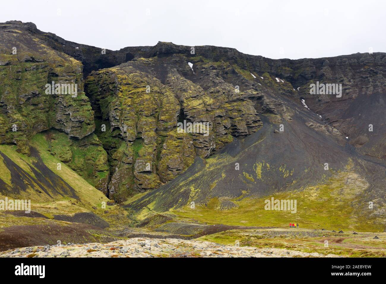 Eine gigantische Kluft in einer Felswand, auf der Südseite der Halbinsel Snaefellsnes in Island entfernt. Einige wenig Touristen auf der rechten Seite zeigen die tatsächliche Stockfoto
