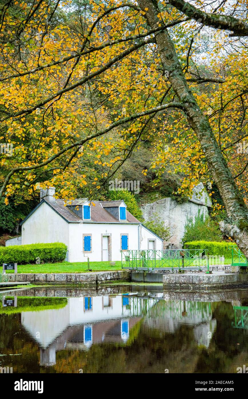 Herbst auf dem Kanal von Nantes nach Brest. Ein kleines weißes Schloss Haus im Wasser am Rand einer Sperre wider Stockfoto