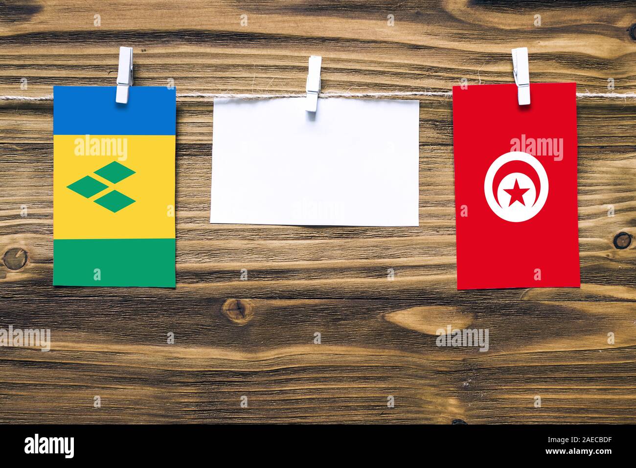 Hängenden Flaggen von St. Vincent und den Grenadinen und Tunesien zu Seil mit wäscheklammer mit Kopie Raum befestigt auf weißem Papier auf Holz backgro Stockfoto