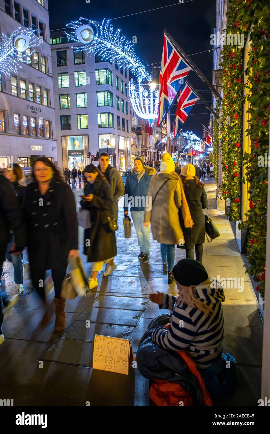 Luxus Geschäfte an der New Bond Street, Bettler, Weihnachten mal in London, Stockfoto