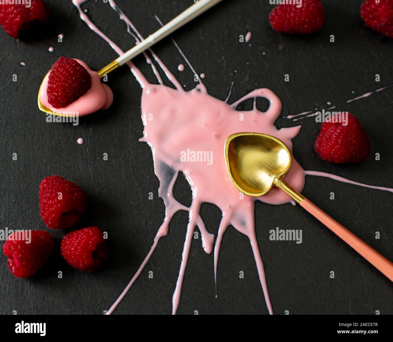 Leuchtend rosa Joghurt Spritzer auf einem dunklen Hintergrund Stockfoto