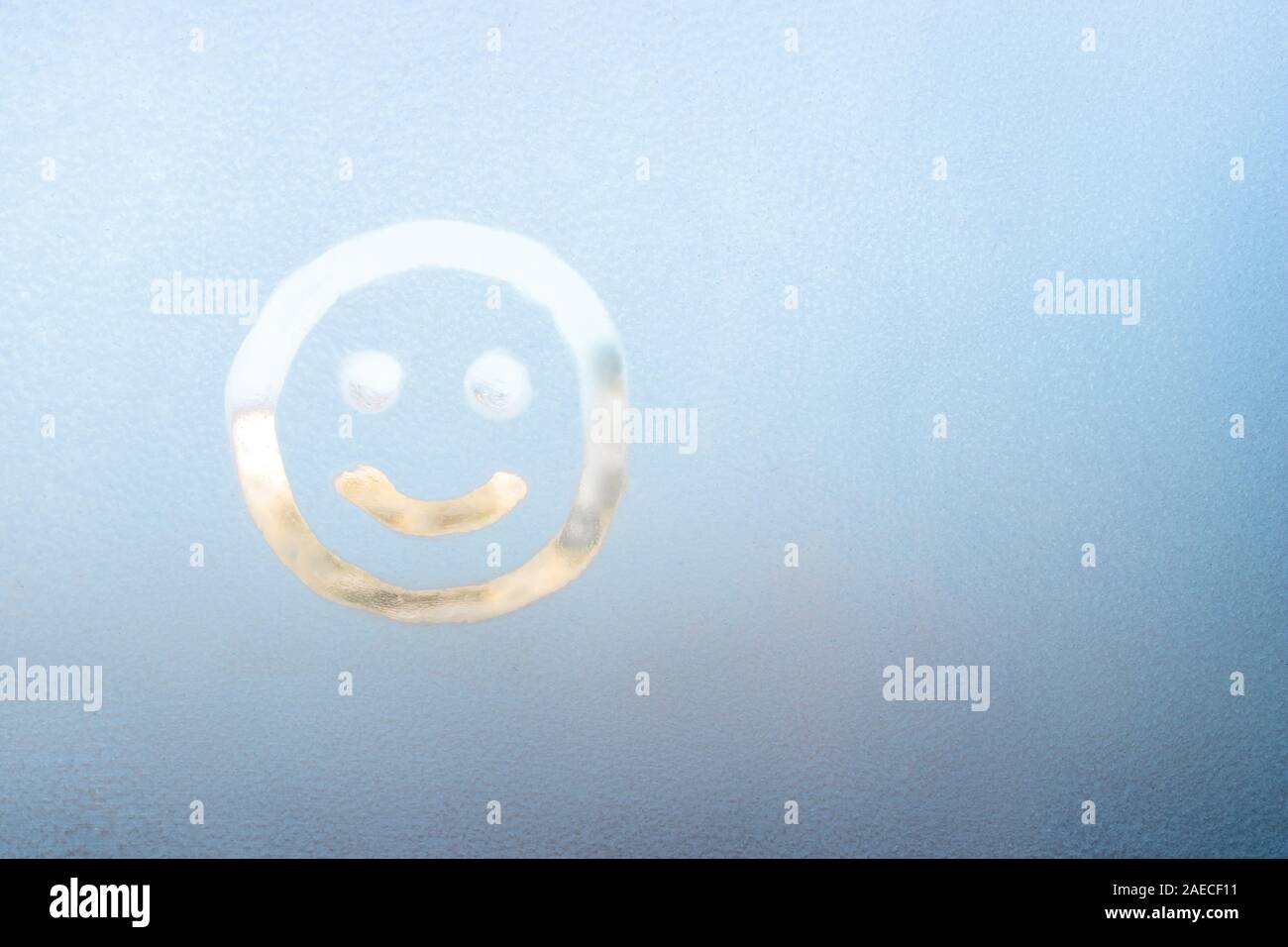 Lächelndes Gesicht auf einem gefrorenen Fenster gemalt, Winter Spaß,  Jahreszeit und hoffen, Konzept, Text, Copyspace Stockfotografie - Alamy
