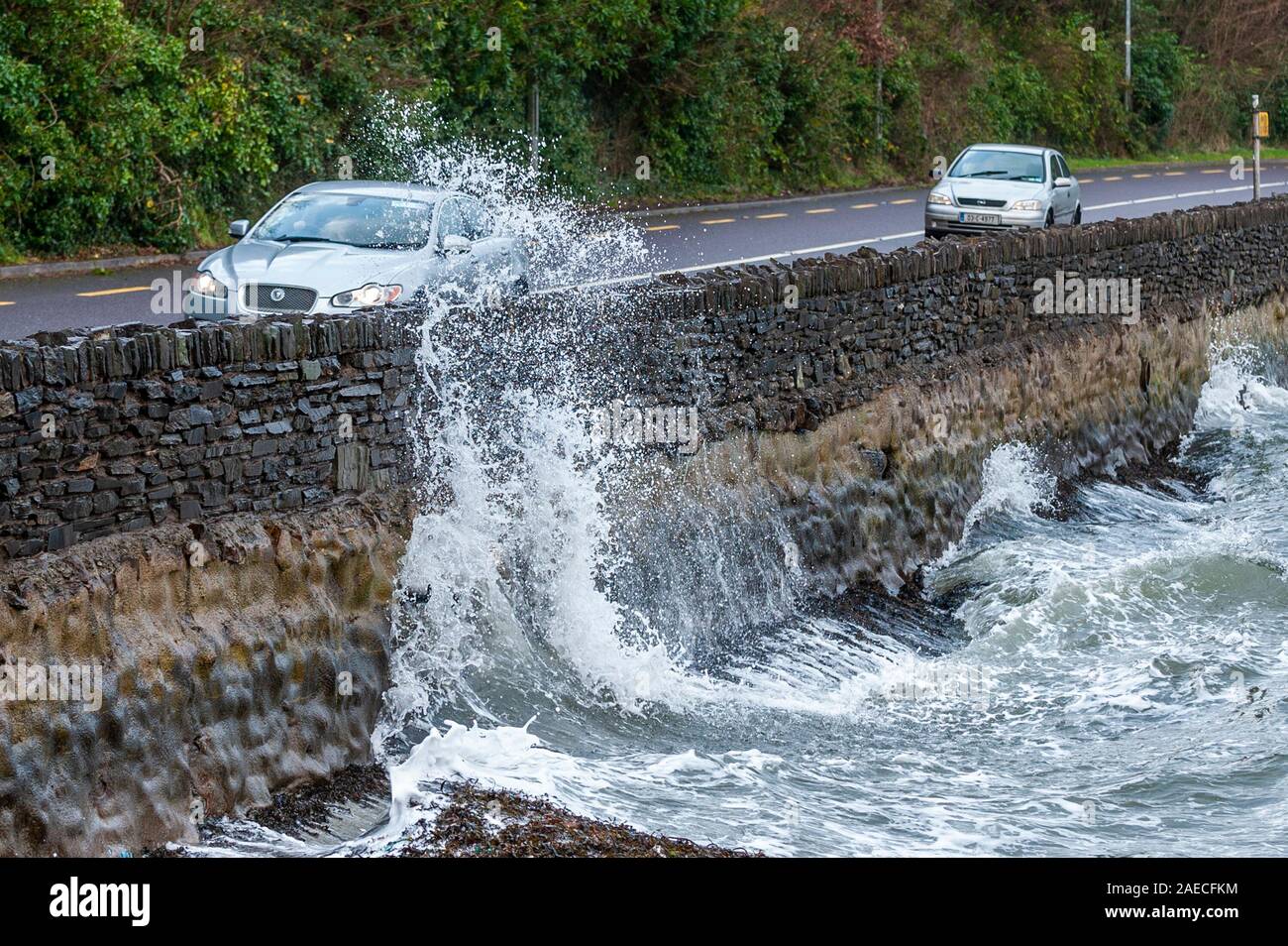 Bantry, West Cork, Irland. Dezember 2019. Sturm Atiyah traf West Cork an diesem Nachmittag mit Winden bis zu 100kmh. Ein Auto fährt entlang der N71 nach Bantry, während große Wellen die Meeresmauer durchbrechen. Quelle: AG News/Alamy Live News Stockfoto