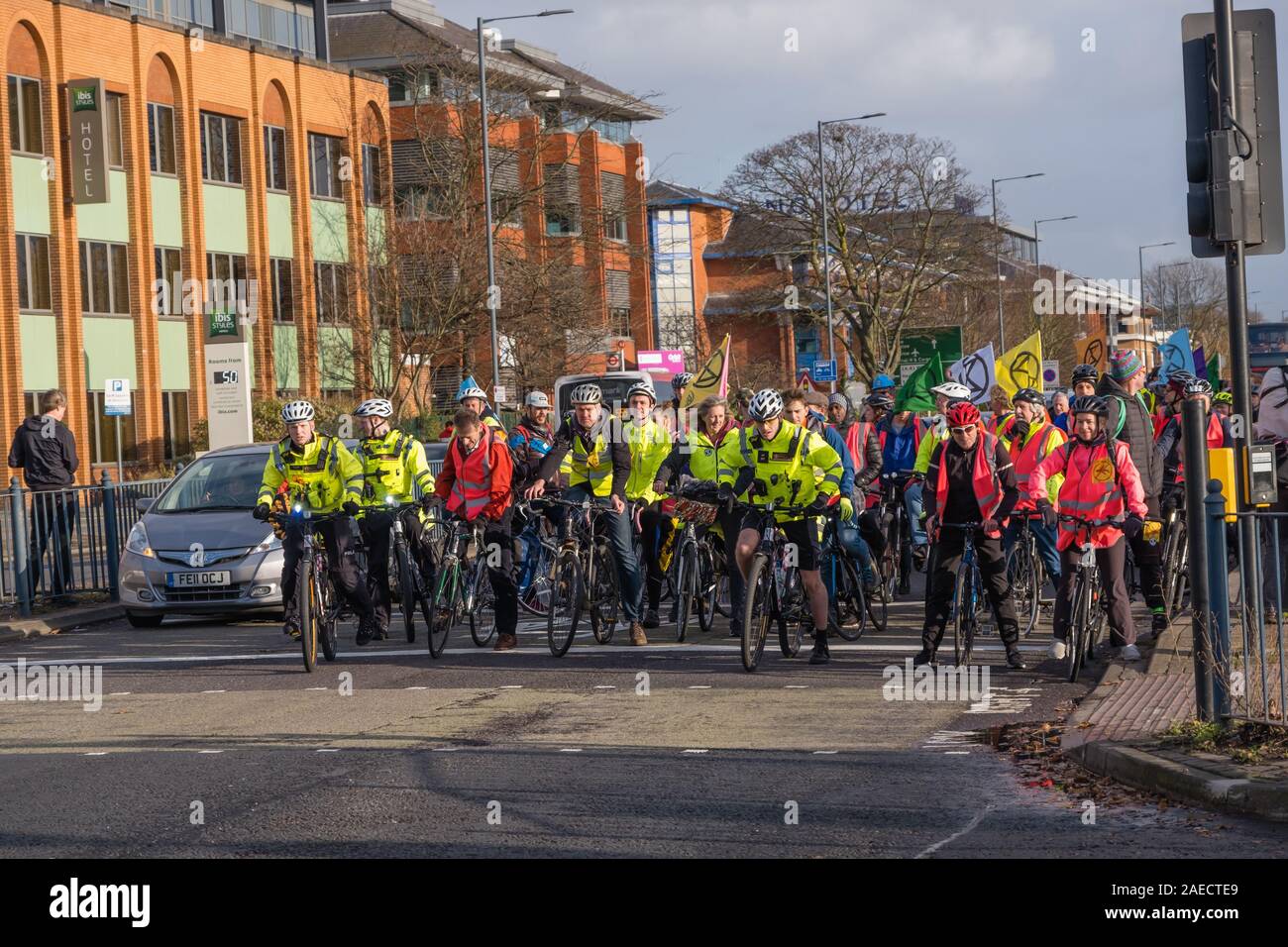 London, Großbritannien. 8. Dezember 2019. Aussterben Rebellion Radfahrer Eintreffen am Flughafen Heathrow in London von der Polizei eine Lüge-in Vor einem Bulldozer in Heathrow zu halten wiederholt Boris Johnson's versprach er mit John McDonnell' vor die Bulldozer liegen würden und den Bau der dritten Start- und Landebahn". Sie brachten die Bulldozer, aber Boris nicht drehen. Polizei angehalten, sie zu den Heathrow Kreisverkehr gehen und statt dessen den Protest blockiert eine Fahrspur der A 4. Peter Marshall / alamy Leben Nachrichten Stockfoto