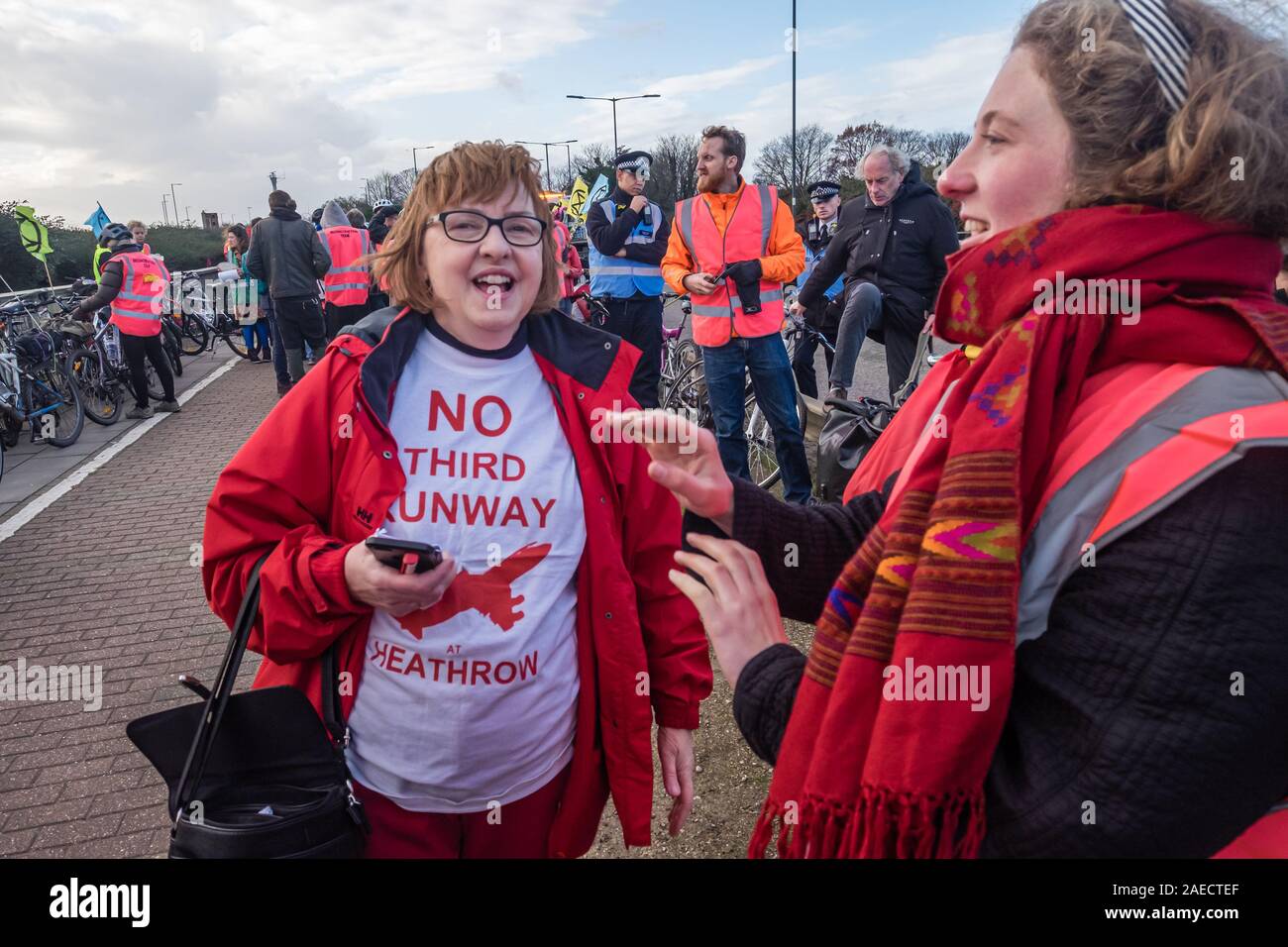 London, Großbritannien. 8. Dezember 2019. Lokaler Bewohner Christine Taylor, Kampagnen gegen Heathrow Expansion Seit über 20 Jahren am Aussterben Rebellion Protest auf der A4-Brücke über den Ansatz zum Flughafen Heathrow. XR war gekommen, eine Lüge - aus Protest gegen die Erweiterung des Flughafens vor einen Bulldozer mit dem Heathrow Kreisverkehr echo Boris Johnson's versprochen, er würde sich mit John McDonnell' vor die Bulldozer und den Bau der dritten Start- und Landebahn" zu halten. XR brachte die Bulldozer, aber Boris nicht drehen. Polizei angehalten, sie zu den Heathrow Kreisverkehr gehen und statt. Stockfoto