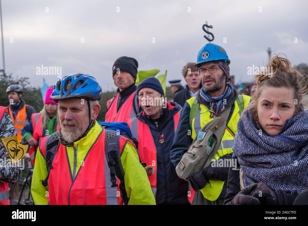 London, Großbritannien. 8. Dezember 2019. Aussterben Rebellion Demonstranten hören am Ende der Lüge - aus Protest gegen die Erweiterung des Flughafens vor einen Bulldozer mit dem Heathrow Kreisverkehr echo Boris Johnson's versprochen, er würde sich mit John McDonnell' vor die Bulldozer und den Bau der dritten Start- und Landebahn". XR brachte die Bulldozer, aber Boris nicht drehen. Polizei angehalten, sie zu den Heathrow Kreisverkehr gehen und statt dessen den Protest blockiert eine Fahrspur der A 4. Peter Marshall / alamy Leben Nachrichten Stockfoto