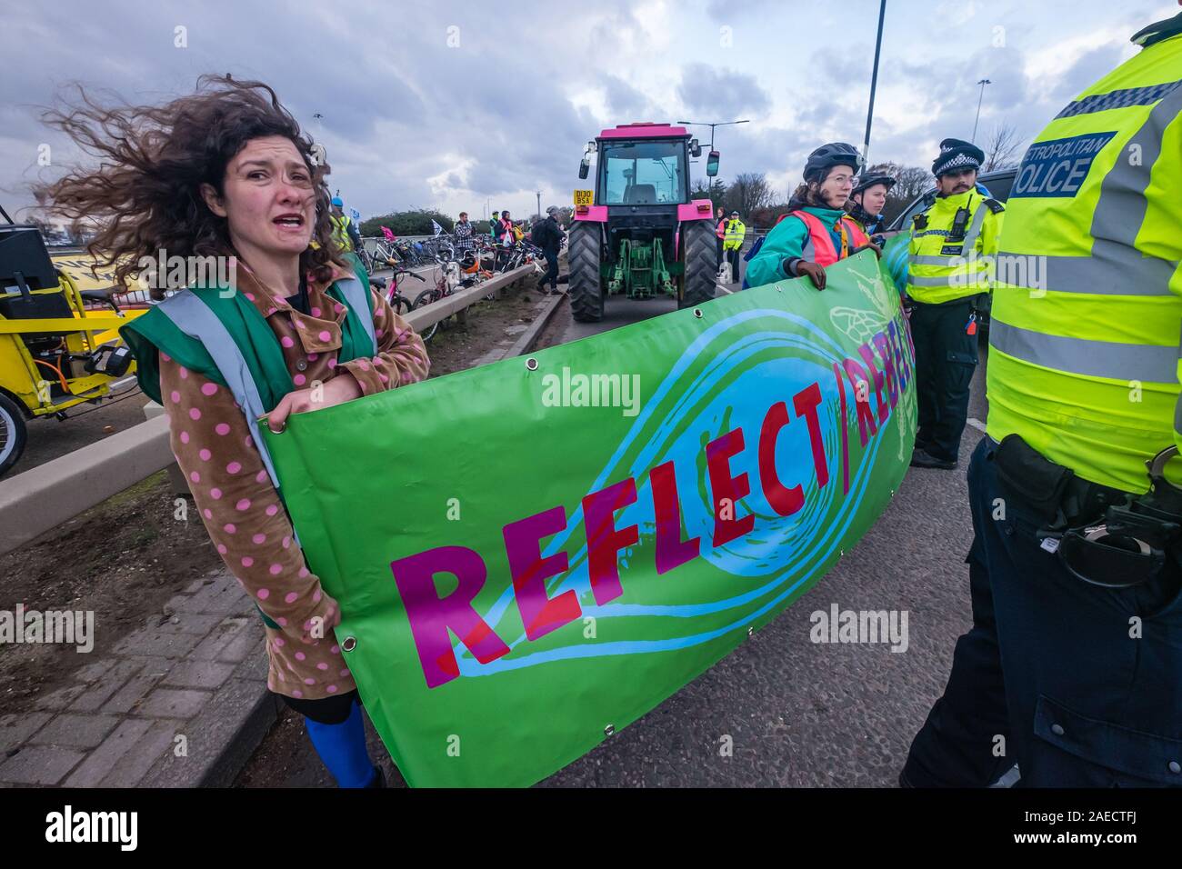 London, Großbritannien. 8. Dezember 2019. Aussterben Rebellion Radfahrer Anschlag auf der A4-Brücke über den Ansatz in Heathrow am Ende ihrer Fahrt vom Zentrum Londons entfernt. Sie waren gekommen, eine Lüge - aus Protest gegen die Erweiterung des Flughafens vor einen Bulldozer mit dem Heathrow Kreisverkehr echo Boris Johnson's versprochen, er würde sich mit John McDonnell' vor die Bulldozer und den Bau der dritten Start- und Landebahn" zu halten. XR brachte die Bulldozer, aber Boris nicht drehen. Polizei angehalten, sie zu den Heathrow Kreisverkehr gehen und statt dessen den Protest blockiert eine Fahrspur der A 4. Peter Marshall/Al Stockfoto