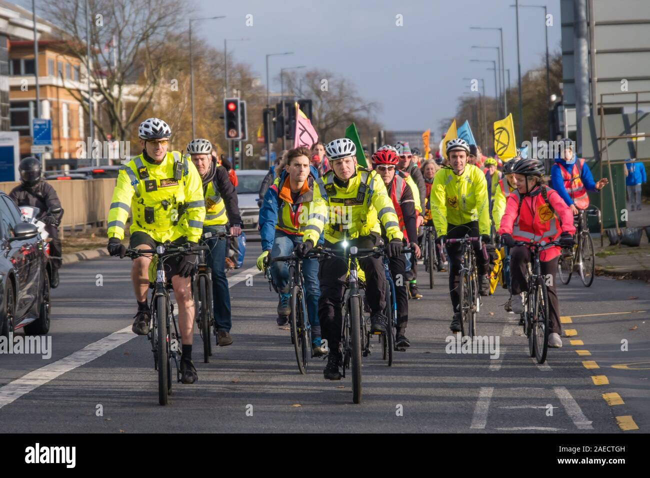 London, Großbritannien. 8. Dezember 2019. Aussterben Rebellion Radfahrer Eintreffen am Flughafen Heathrow in London von der Polizei eine Lüge-in Vor einem Bulldozer in Heathrow zu halten wiederholt Boris Johnson's versprach er mit John McDonnell' vor die Bulldozer liegen würden und den Bau der dritten Start- und Landebahn". Sie brachten die Bulldozer, aber Boris nicht drehen. Polizei angehalten, sie zu den Heathrow Kreisverkehr gehen und statt dessen den Protest blockiert eine Fahrspur der A 4. Peter Marshall / alamy Leben Nachrichten Stockfoto