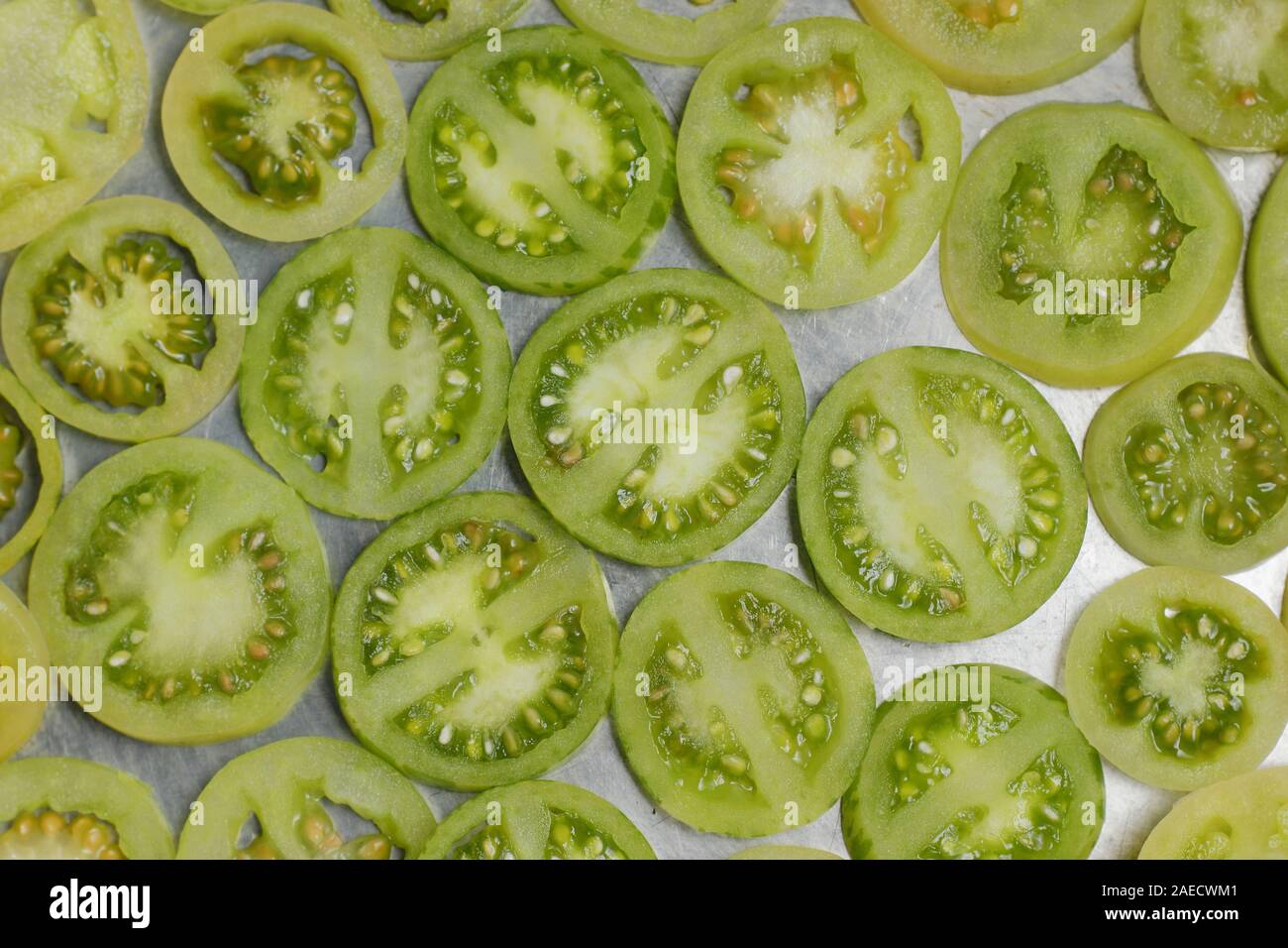 Solanum Lycopersicum. Scheiben der unreife grüne Tomaten n der Pfanne. Stockfoto