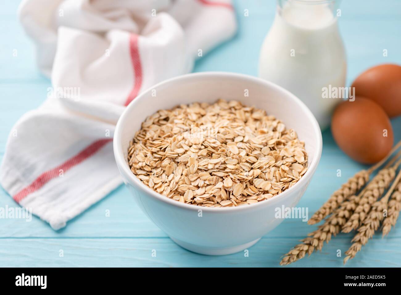 Hafer, Milch und Eier auf Blau Holztisch. Zutaten für ein gesundes Frühstück Stockfoto