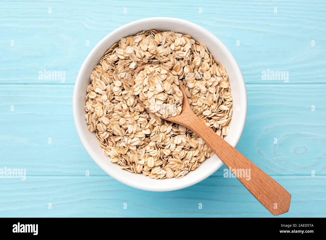 Haferflocken, Haferflocken in der Schüssel auf blauem Hintergrund Stockfoto