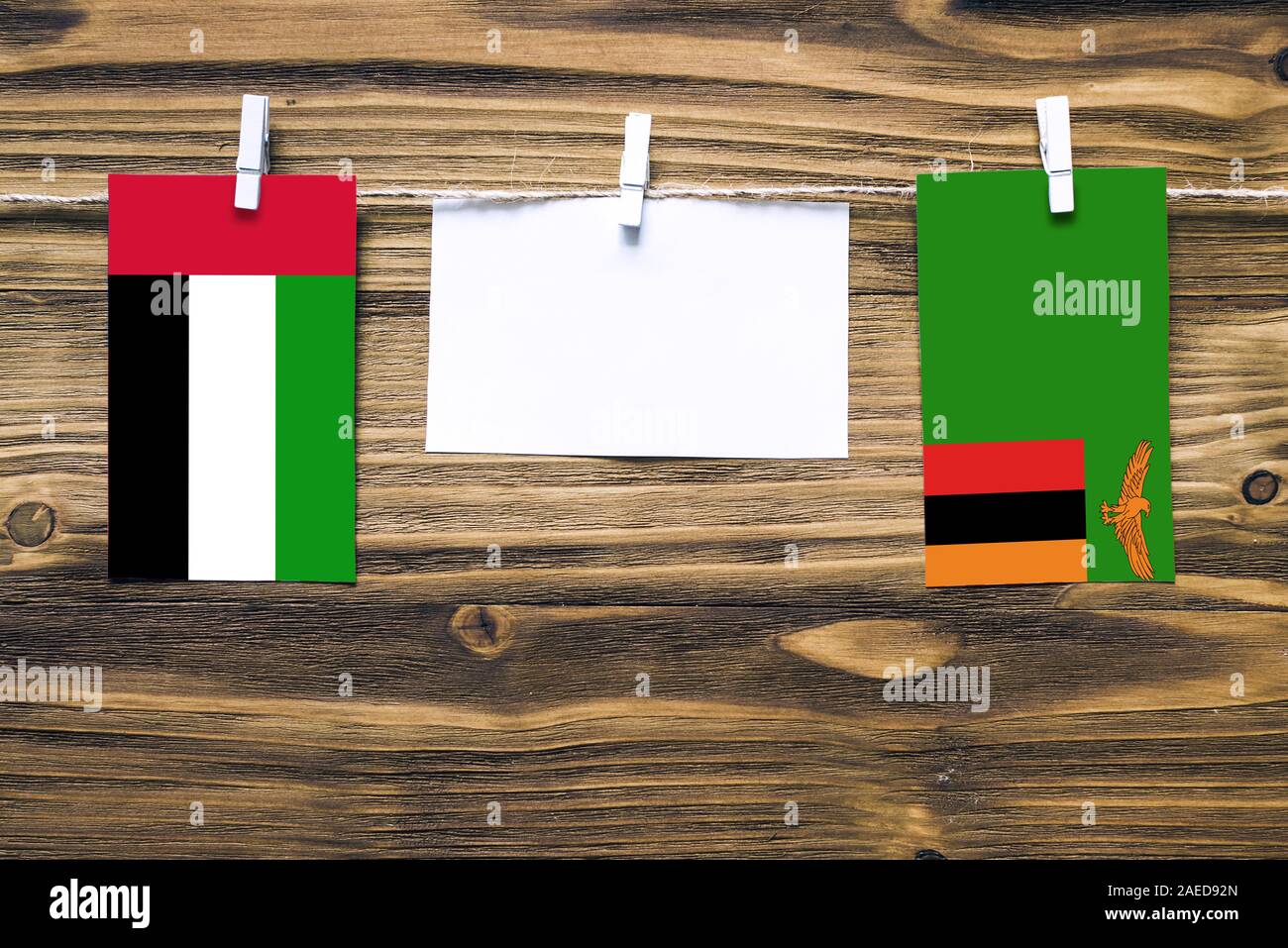 Hängenden Flaggen der Vereinigten Arabischen Emirate und Sambia Seil mit  wäscheklammer mit Kopie Raum befestigt auf weißem Papier auf Holz-  Hintergrund. Diplomati Stockfotografie - Alamy