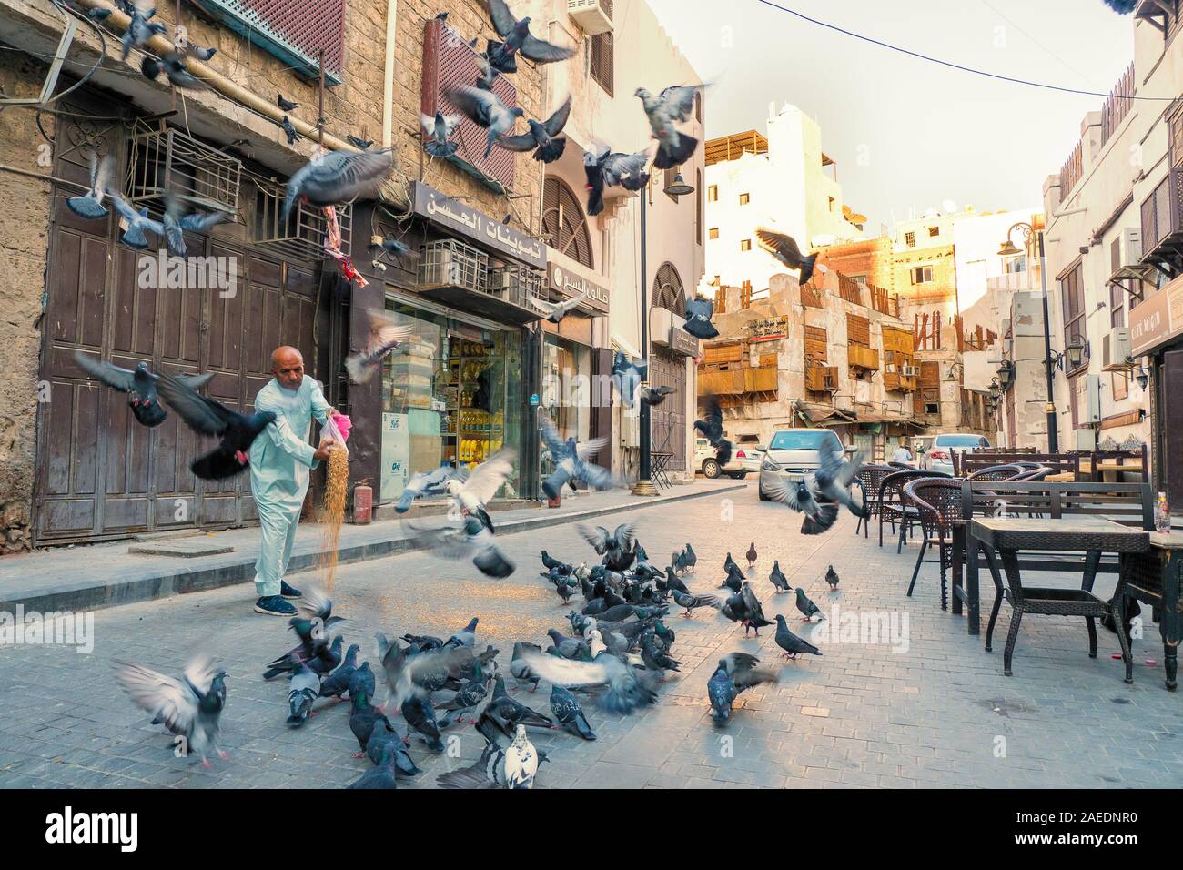 Arabisch senior füttern Tauben in einer Straße im historischen Bezirk Al Balad in Jeddah, KSA, Saudi-Arabien Stockfoto