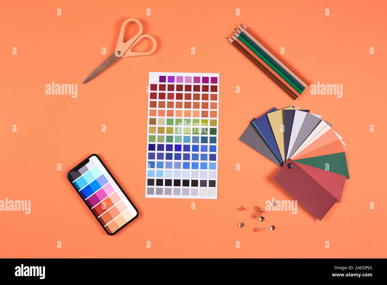 Oben Ansicht Flach der Farbpalette Proben und Muster an Designer Arbeitsplatz über orange leuchtenden Hintergrund, kopieren Raum Stockfoto