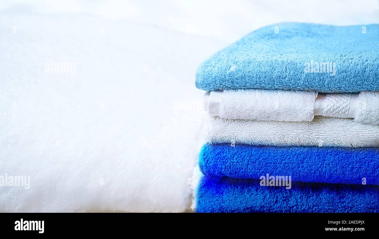 Stapel Handtücher in Weiß und Blau, auf weissem Schnee, isoliert. Classic blau Farbe des Jahres 2020. Stockfoto