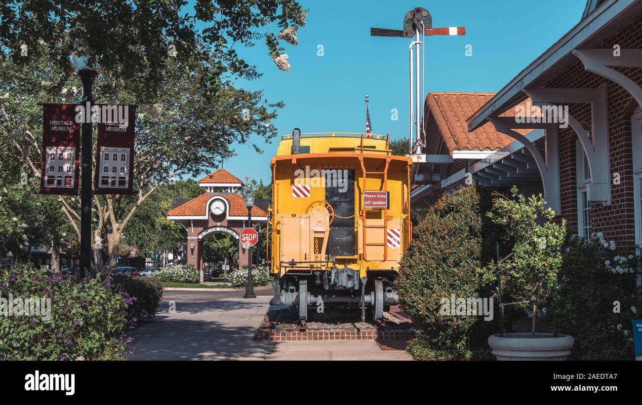WINTER GARDEN, Florida: 29. Mai 2019 - Historische gelbe Eisenbahn Auto vor dem Clock Tower und neben dem Heritage Museum in der Innenstadt liegt. Stockfoto
