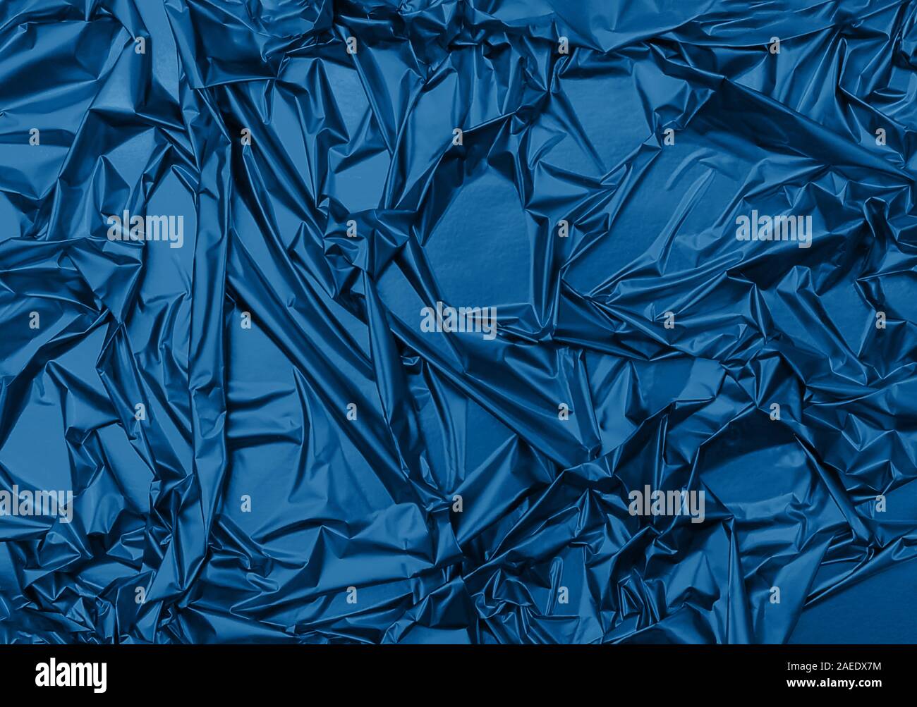 Glänzend zerknitterten Oberfläche der trendigen Blau Folie für strukturierte Urlaub Hintergrund. Farbe des Jahres Konzept 2020. Hintergrund für Ihr Design. Stockfoto