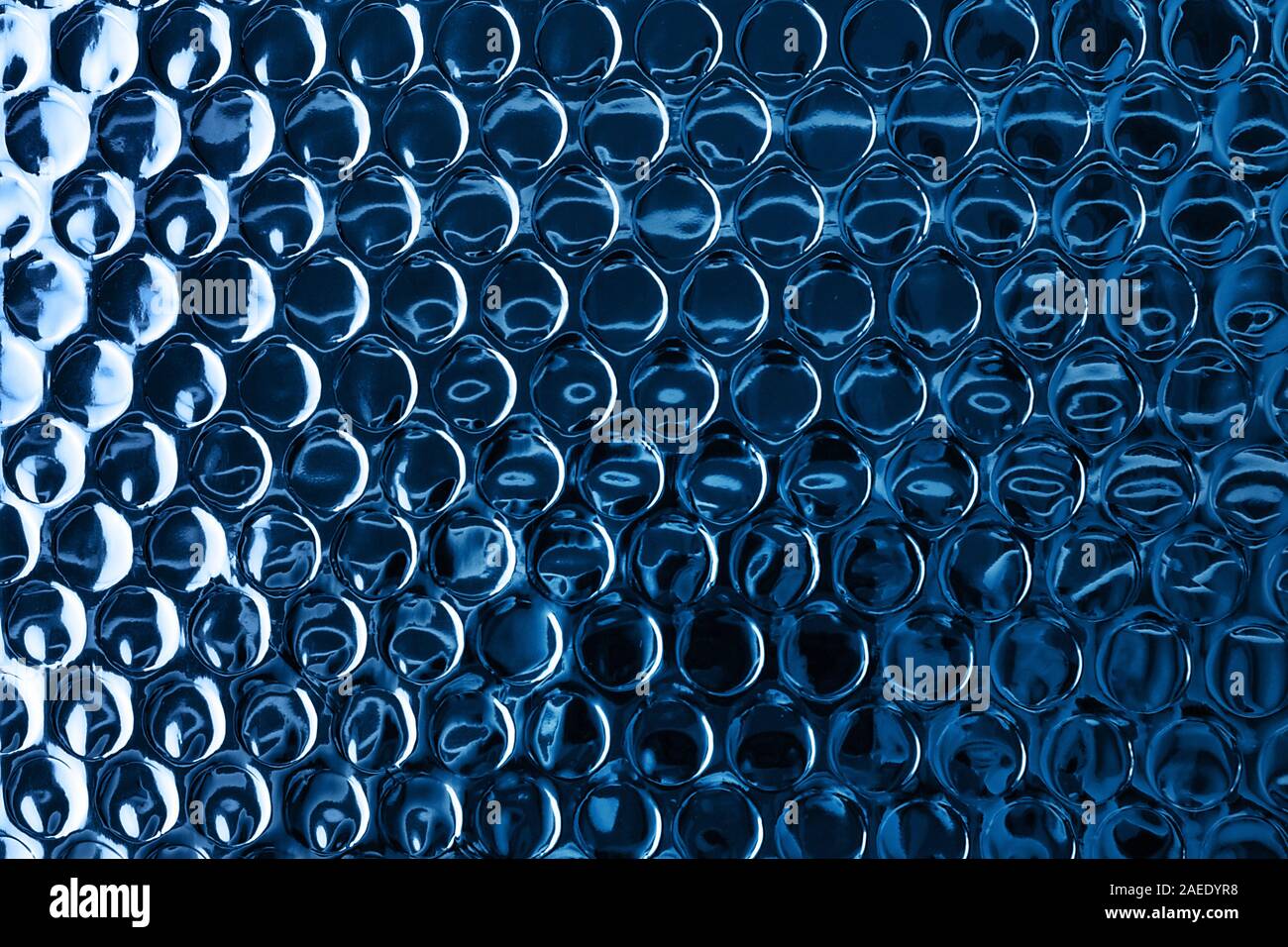 Glänzende blaue Folie Oberfläche mit runden Eindrücke für strukturierten Hintergrund. Farbe des Jahres Konzept 2020. Kopieren Sie Platz. Stockfoto