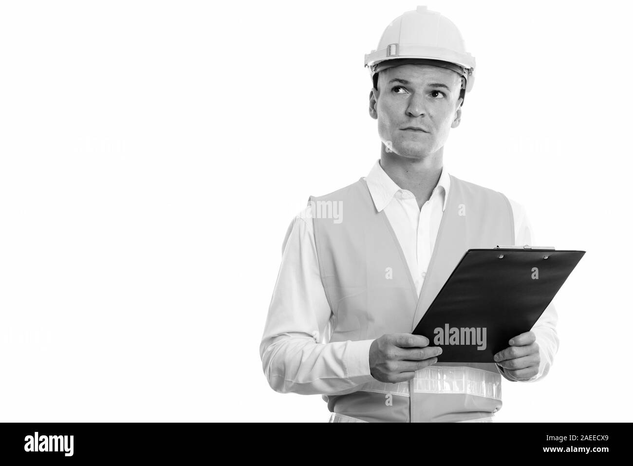 Studio shot Junger stattlicher Mann Bauarbeiter holding Zwischenablage beim Denken Stockfoto