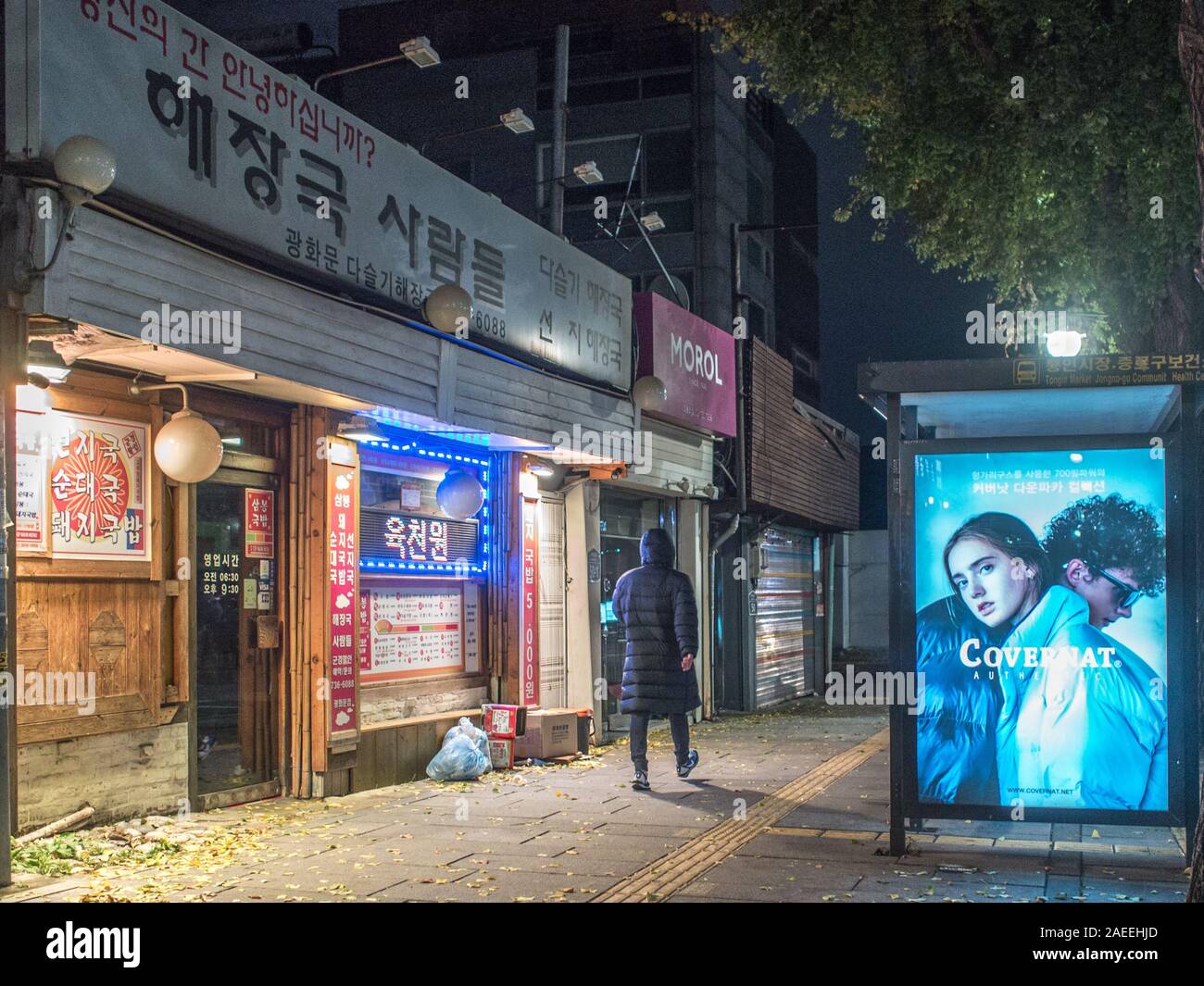 Person zu Fuß vorbei an elektronischen Bildschirm Kleidung Werbung anmelden, Night Street, in der Nähe der Gyeongbokgung Station, Seoul, Südkorea. Stockfoto