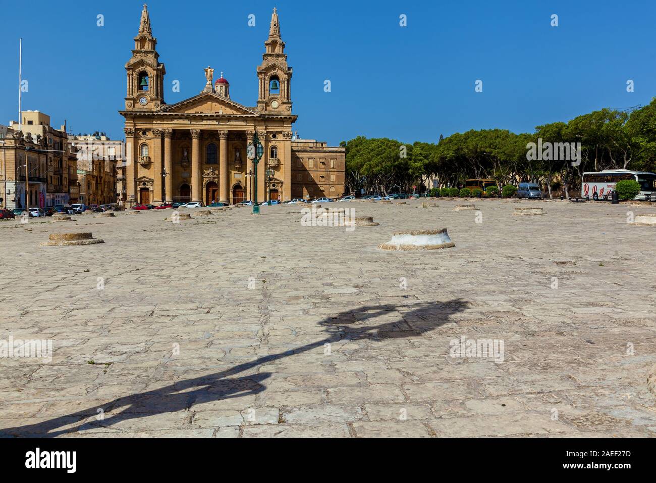 Eine römisch-katholische Pfarrkirche befindet sich an einem großen Platz mit rosa Oleander in Floriana, Malta Stockfoto