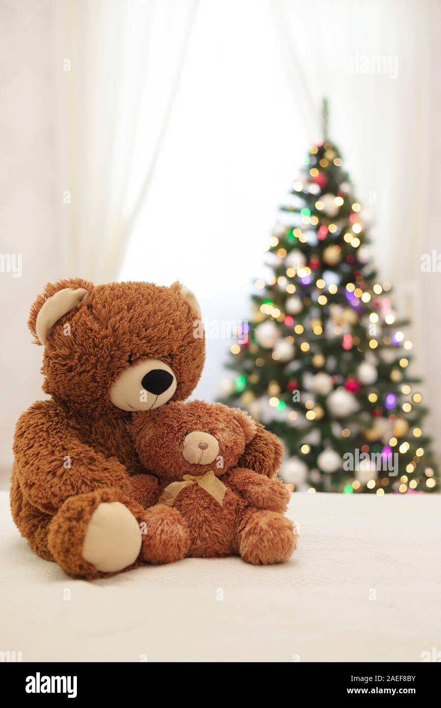 Frohe Weihnachten! Kinder Spielzeug Teddybären Große und Kleine sitzen auf dem Sofa vor dem Hintergrund der Weihnachtsbaum. Selektive konzentrieren. Stockfoto