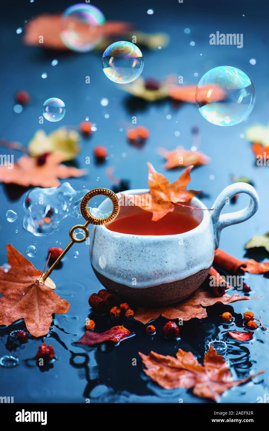 Seifenblasen im Herbst noch Leben mit einem Keramik Teetasse und einer Blase Zauberstab Stockfoto