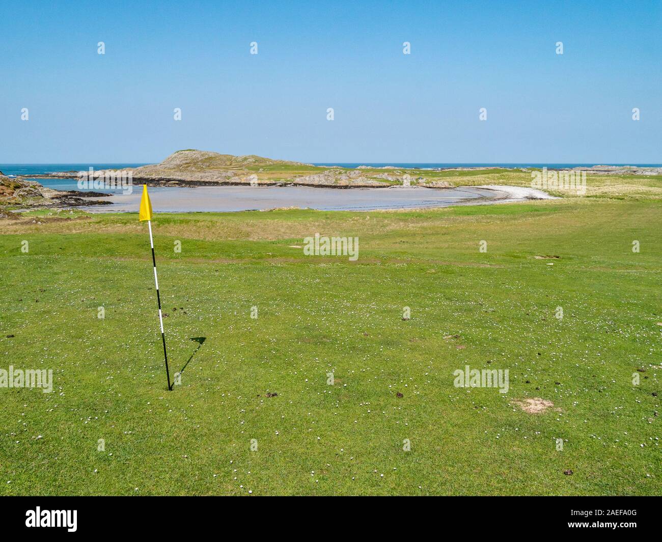 Golfplatz grün mit Flagge und Pole am Meer, Insel Colonsay Golf Club, Schottland, Großbritannien Stockfoto