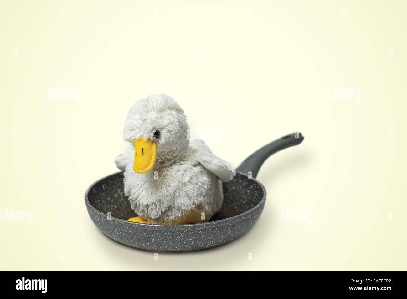 Flauschige toy Huhn auf einer Pfanne Süß. Grausame Fleisch, Geflügelfleisch Konzept Stockfoto