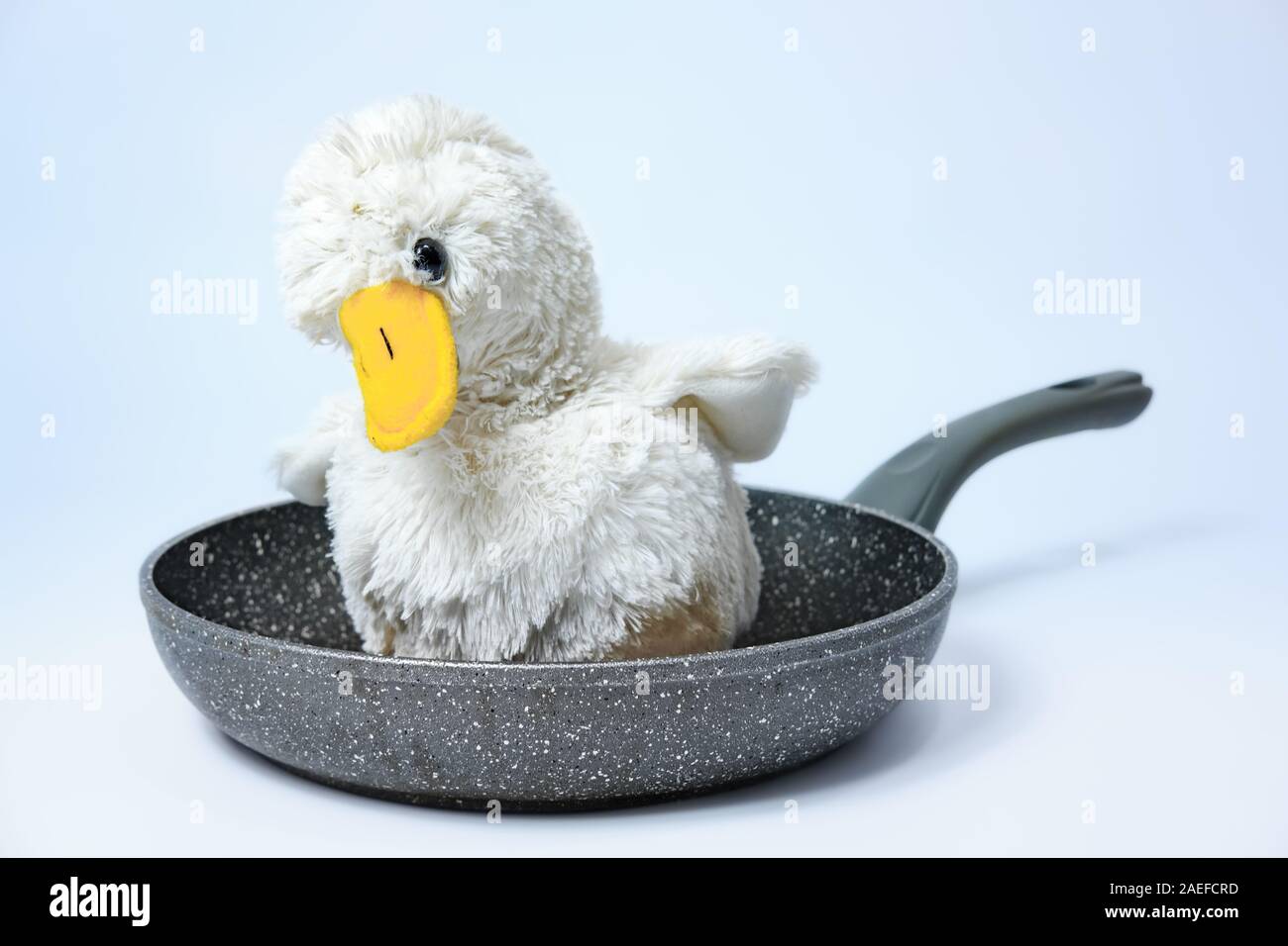 Flauschige toy Huhn auf einer Pfanne Süß. Grausame Fleisch, Geflügelfleisch Konzept Stockfoto