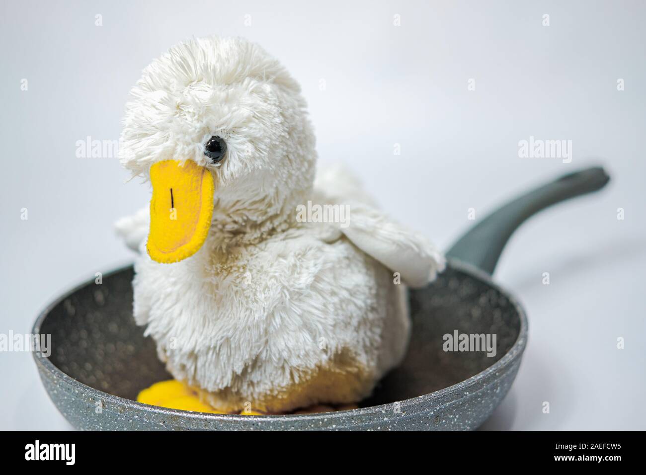 Flauschige toy Huhn auf einer Pfanne Süß. Grausame Fleisch, Geflügelfleisch Konzept Stockfoto