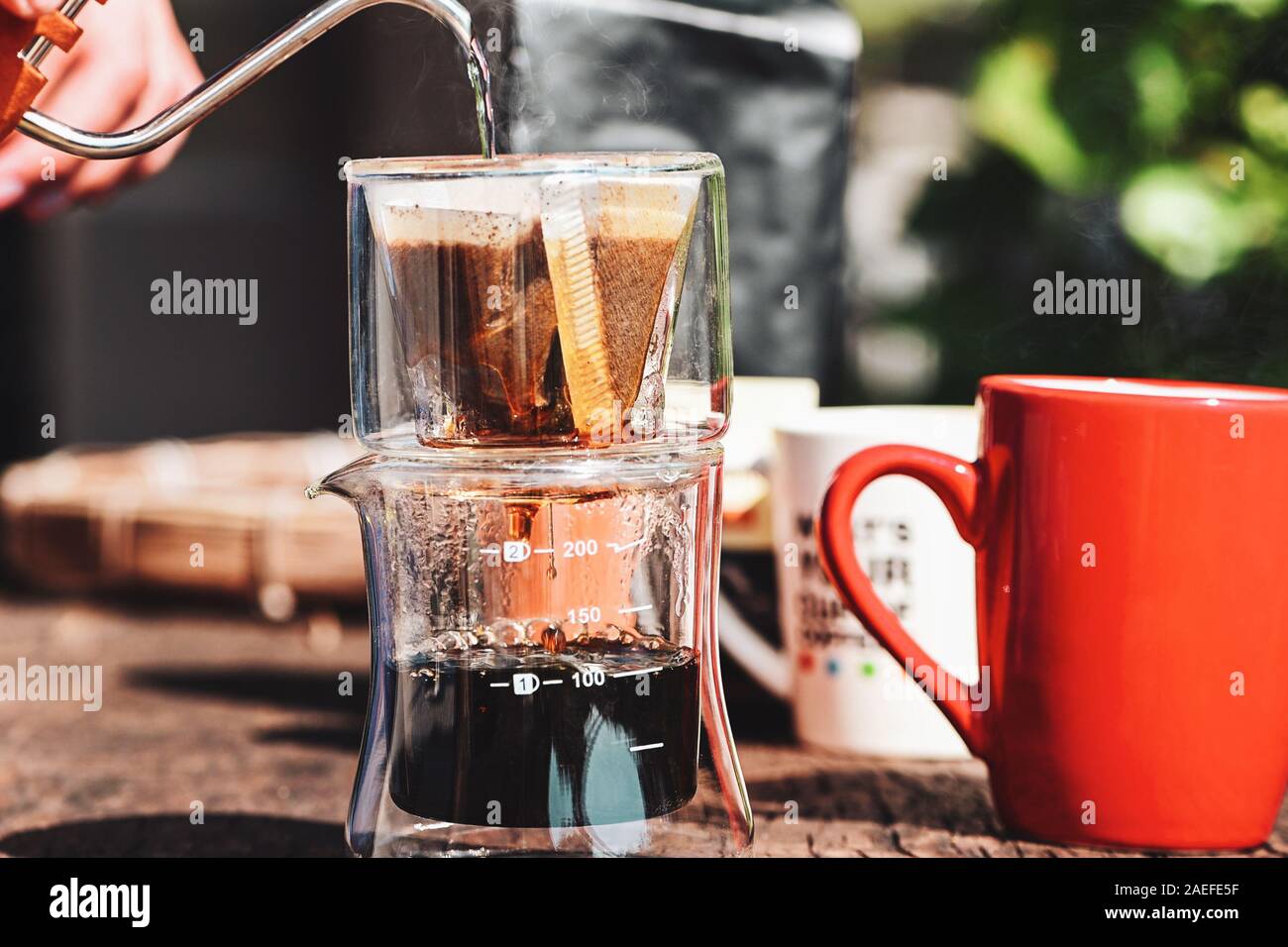 Tropfen Kaffee brühen, Koffein Filter Aroma Becher Tasse. Mann verschüttet  heißes Wasser gefilterten Kaffee transparentes Glas tropfen Teekocher auf  Tisch vorbereiten. Dampf Stockfotografie - Alamy