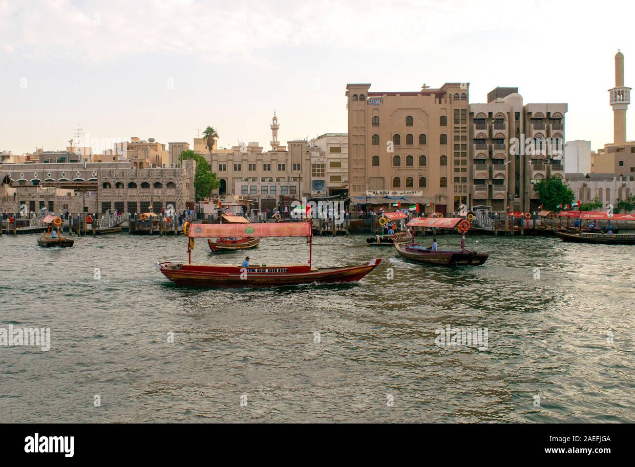 Dubai/VAE - November 9, 2019: Dubai Altstadt Ansicht mit RTA arba Boote auf dem Dubai Creek River. Bur Dubai, alte traditionelle Boote mit Touristen. ... Stockfoto