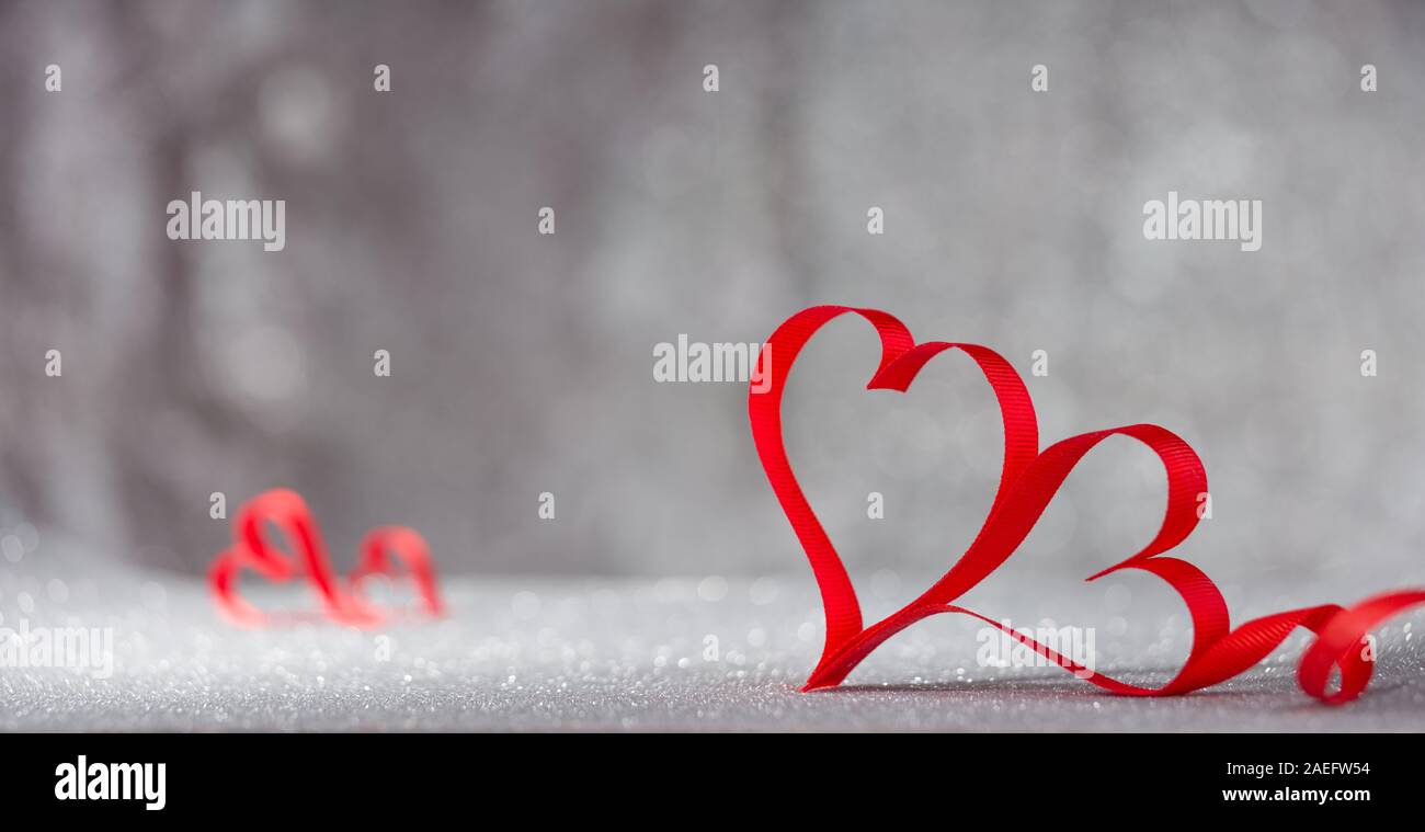 Valentine's Tage Karte. Ribbon geformten roten Herzen auf Holz Tisch Stockfoto