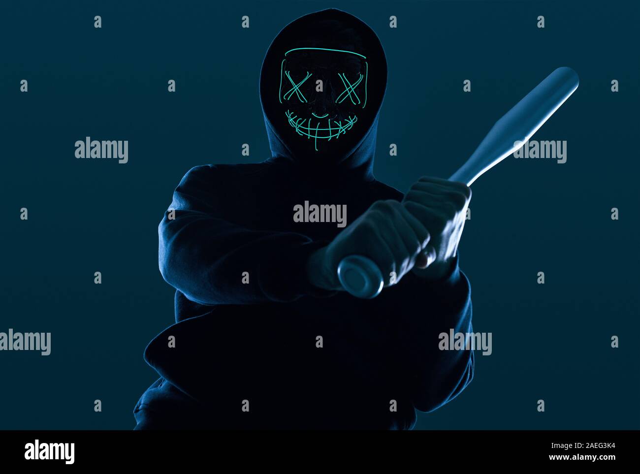 Porträt eines anonymen kriminellen Mann mit Baseballschläger in einer schwarzen Kapuze sein Gesicht hinter einer Maske. Unterer Winkel Stockfoto
