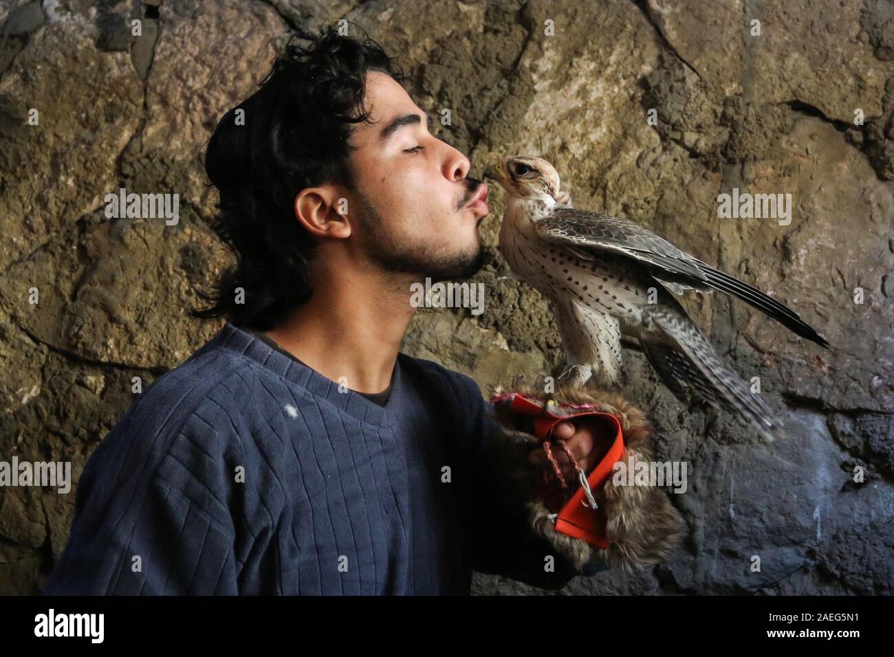 Nuseirat, Gazastreifen, palästinensischen Gebiet. 9 Dez, 2019. Eine palästinensische Jugend Fadel Nabhein posiert für ein Foto mit einem Adler in seinem Haus in der nuseirat regugee Camp im zentralen Gazastreifen, der am 9. Dezember 2019. Nabhein Rassen und zähmt Falken und Schlangen in seinem Haus und sogar in mummifying einige Tiere, nachdem sie starben wegen Wetter oder Krankheit Kredit: Ashraf Amra/APA-Images/ZUMA Draht/Alamy Leben Nachrichten gelungen Stockfoto