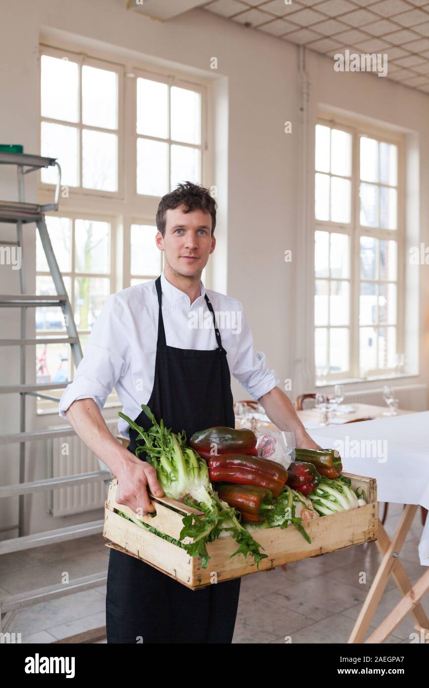 Mann mit Gemüsekorb Restaurant Scheepskameel, Amsterdam, Niederlande Stockfoto