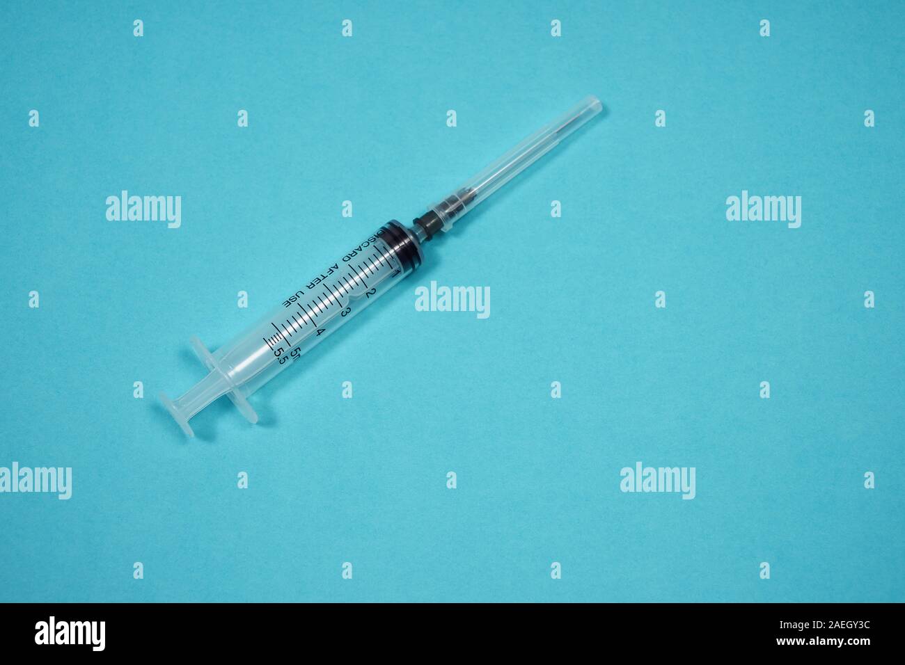 Leere Spritze mit Nadel auf türkisfarbenem Hintergrund. Medizinischer Hintergrund. Behandlung eines Patienten. Konzeptfoto für Drogenabhängige. Kopierbereich Stockfoto