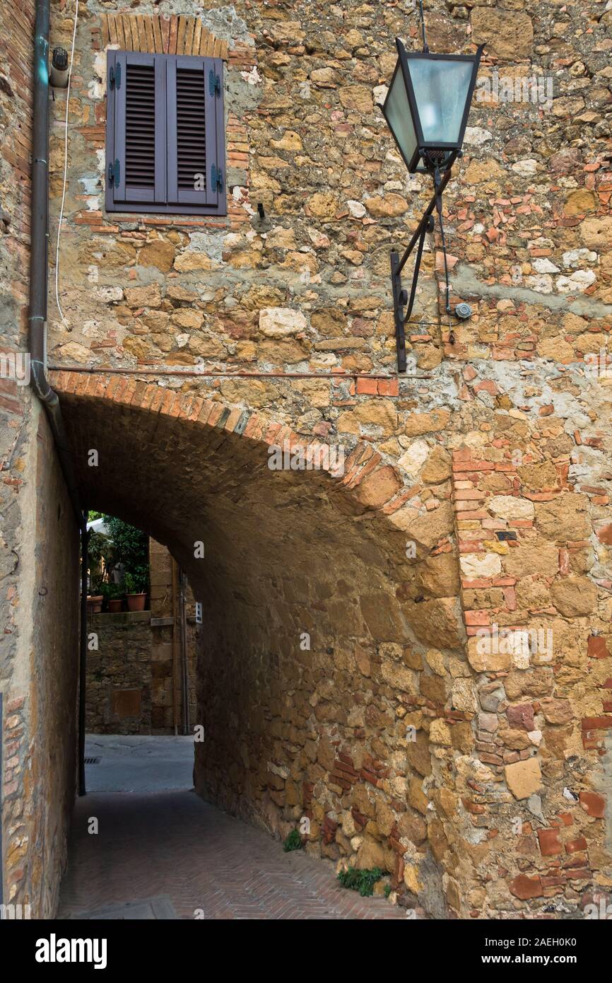 Kleine Passage zwischen engen und gewundenen Straßen von Pienza, Provinz Siena, Toskana, Italien Stockfoto