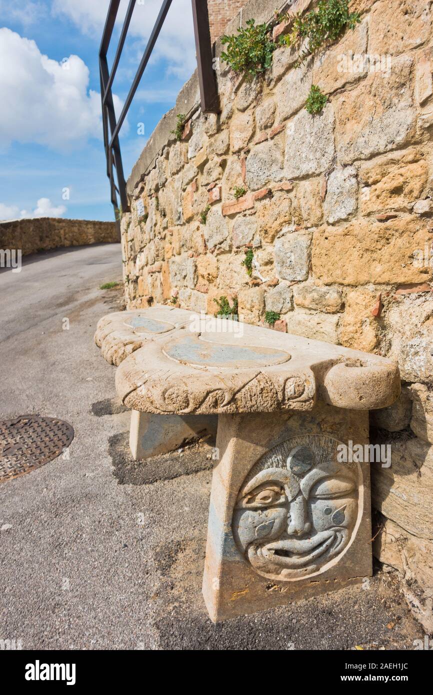 Sitzbank aus Stein vor der alten Steinmauer, Detail von Straßen von voltera in der Toskana, Italien Stockfoto