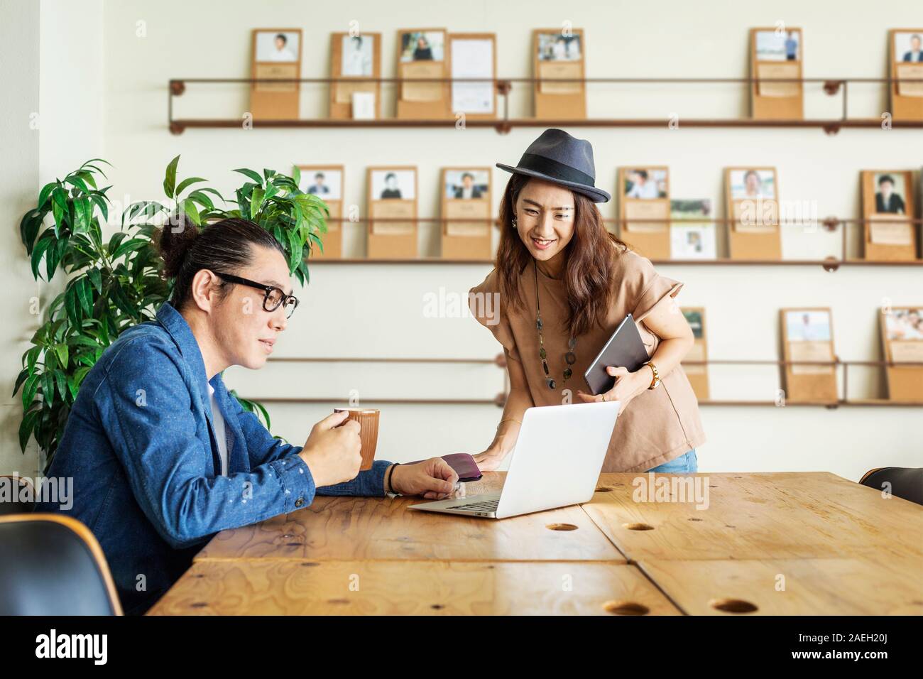 Männliche und weibliche Japanische Fachmann an einem Tisch in einem Co-Arbeitsplatz, mit Laptop Computer. Stockfoto