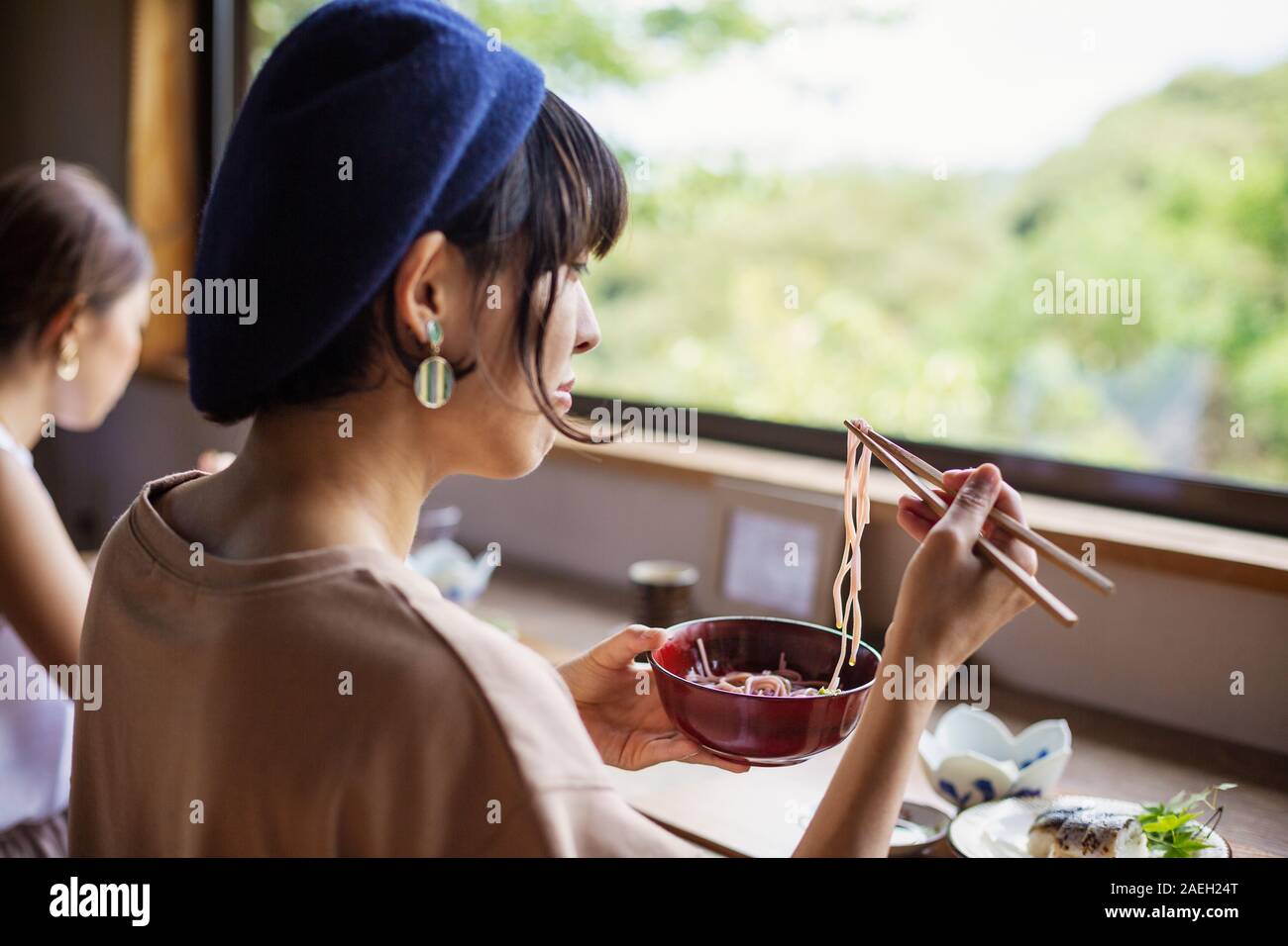 Zwei japanische Frauen an einem Tisch sitzen in einem Japanischen Restaurant, Essen. Stockfoto