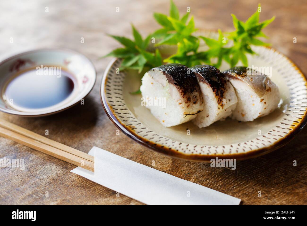 Hohen Winkel in der Nähe von Platte von Sushi und Schüssel von Soja Sauce auf einem Tisch in ein japanisches Restaurant. Stockfoto