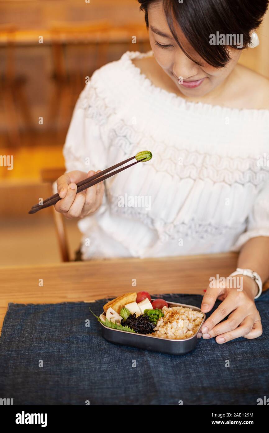 Japanische Frauen Essen mit Stäbchen in einer vegetarischen Cafe. Stockfoto
